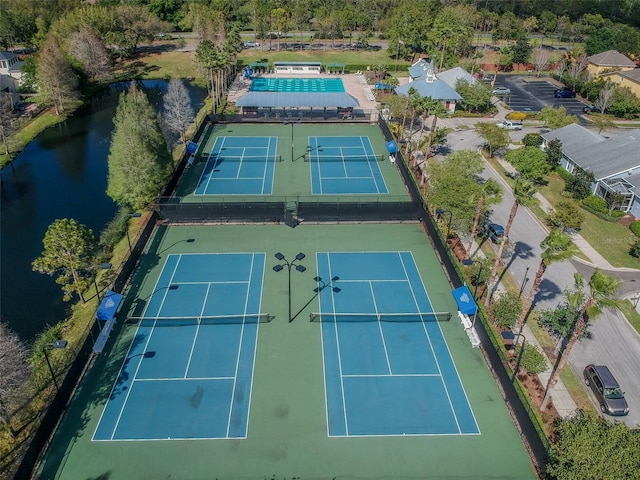 view of sport court with a water view and fence