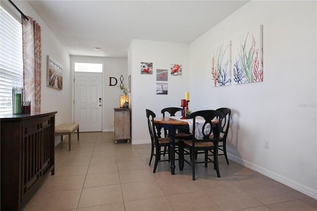 dining room featuring a healthy amount of sunlight, baseboards, and light tile patterned flooring