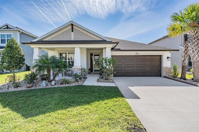 craftsman house featuring driveway, an attached garage, a front lawn, a porch, and stucco siding