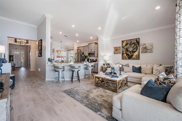 living room with crown molding, lofted ceiling, light wood-style flooring, an inviting chandelier, and baseboards