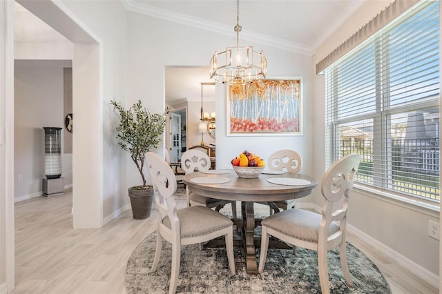 dining area featuring baseboards, ornamental molding, light wood-style floors, and an inviting chandelier