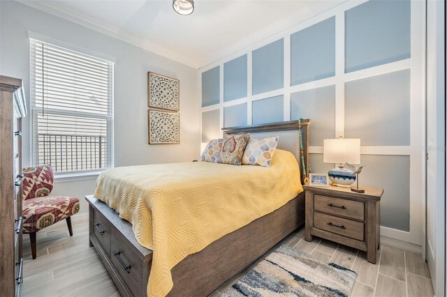 bedroom with ornamental molding and wood finish floors