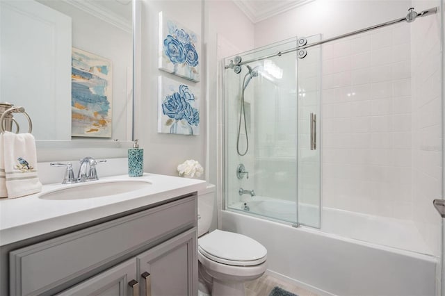 bathroom featuring ornamental molding, vanity, toilet, and bath / shower combo with glass door