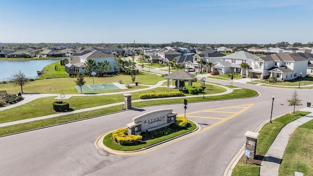 view of street with street lighting, a water view, sidewalks, a residential view, and curbs