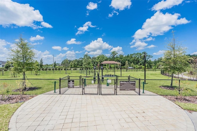 view of home's community featuring a lawn, fence, and a gate