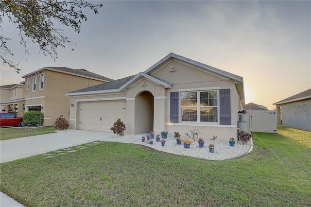 view of front of house with a garage, driveway, a front lawn, and stucco siding