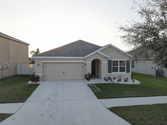 ranch-style home with driveway, a front yard, and stucco siding