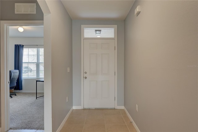 interior space featuring light tile patterned floors, arched walkways, visible vents, and baseboards