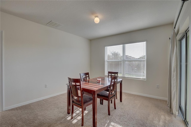 dining area with light carpet, baseboards, and visible vents