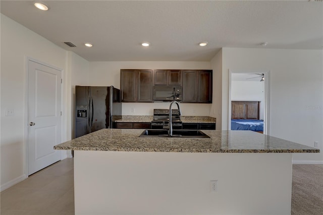 kitchen featuring visible vents, dark brown cabinets, black appliances, a sink, and recessed lighting