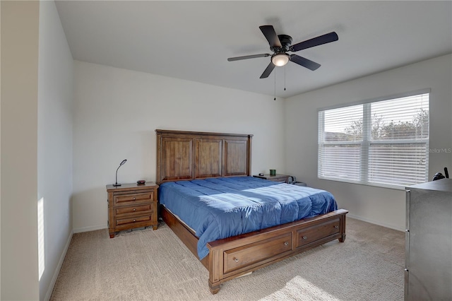 bedroom with baseboards, a ceiling fan, and light colored carpet