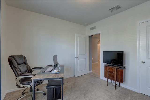 carpeted office space featuring baseboards, visible vents, and arched walkways