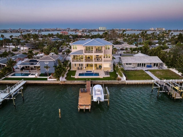 aerial view at dusk with a residential view and a water view