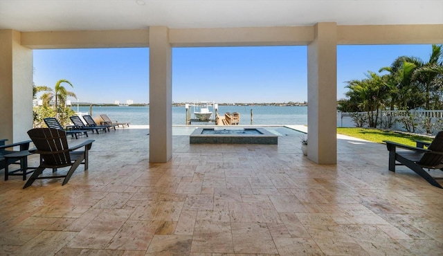 view of patio featuring a fire pit, a water view, and fence