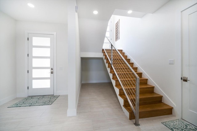 foyer with baseboards, stairway, and recessed lighting