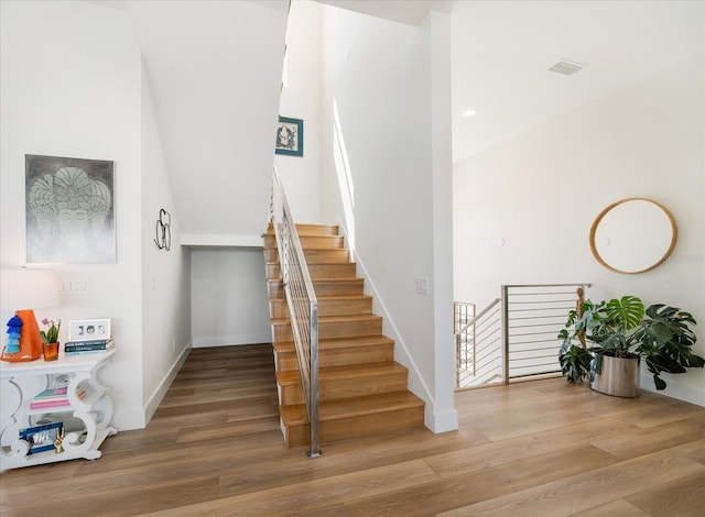 stairs featuring visible vents, baseboards, and wood finished floors