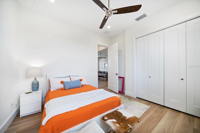 bedroom featuring a closet, visible vents, baseboards, and wood finished floors