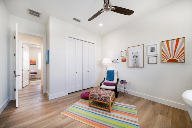 sitting room with baseboards, visible vents, and light wood-style floors