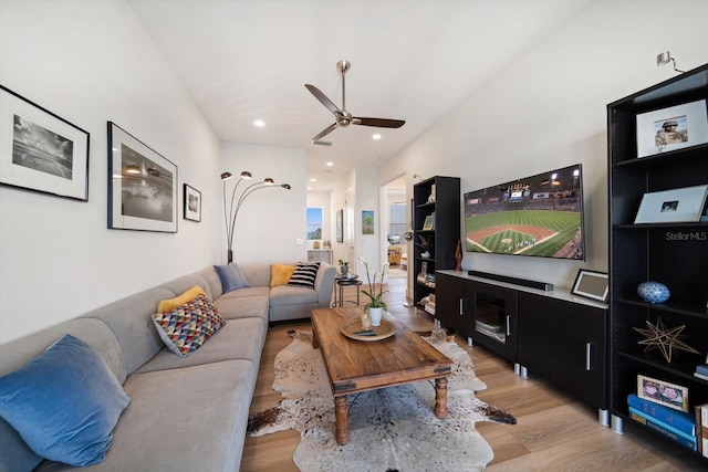 living room with light wood-style flooring, a ceiling fan, and recessed lighting