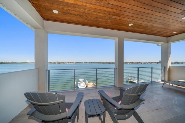 view of patio with a water view and a balcony