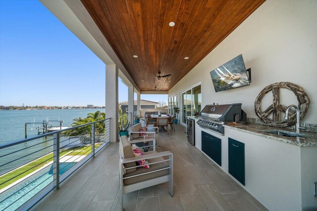 view of patio featuring exterior kitchen, a sink, a balcony, and area for grilling