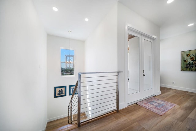 foyer entrance with baseboards, a chandelier, wood finished floors, and recessed lighting