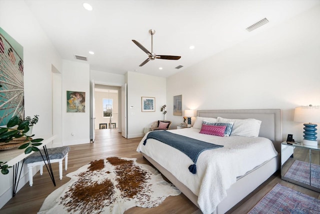 bedroom with baseboards, visible vents, wood finished floors, and recessed lighting