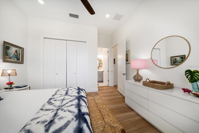 bedroom with a closet, light wood-type flooring, visible vents, and recessed lighting