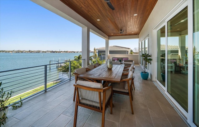 balcony featuring outdoor dining space and a water view