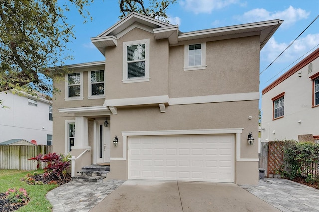 traditional-style home with stucco siding, an attached garage, and fence