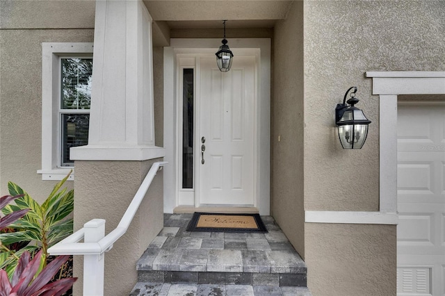 doorway to property featuring a garage and stucco siding