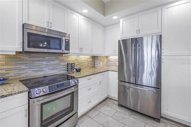 kitchen with appliances with stainless steel finishes, decorative backsplash, and white cabinets