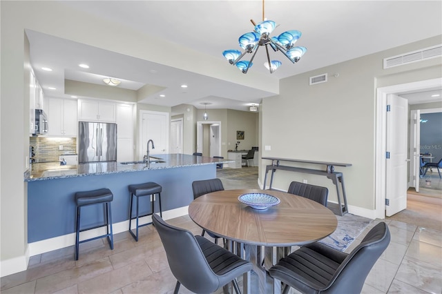 dining room featuring a chandelier, recessed lighting, visible vents, and baseboards