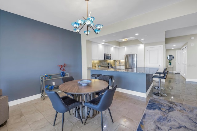 dining room with a chandelier, recessed lighting, and baseboards