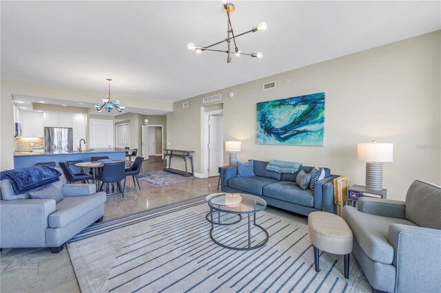 living room with baseboards, visible vents, and an inviting chandelier