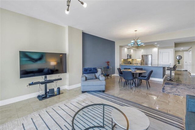 living room featuring an inviting chandelier and baseboards