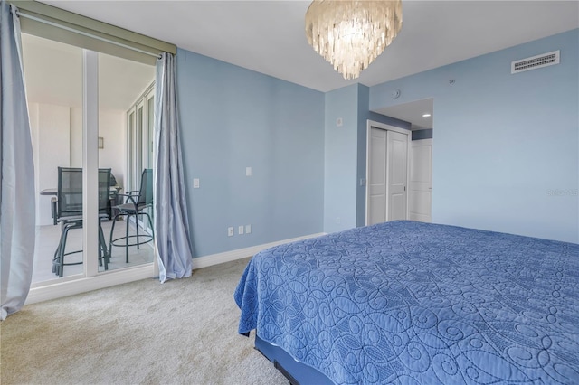 carpeted bedroom with baseboards, a closet, visible vents, and a notable chandelier