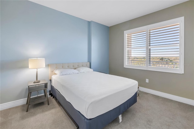 bedroom with baseboards and light colored carpet