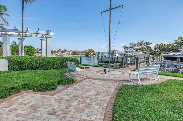 view of property's community with a boat dock, boat lift, a water view, a yard, and a pergola