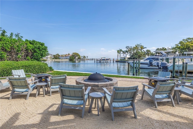 view of patio featuring a fire pit, a boat dock, and a water view