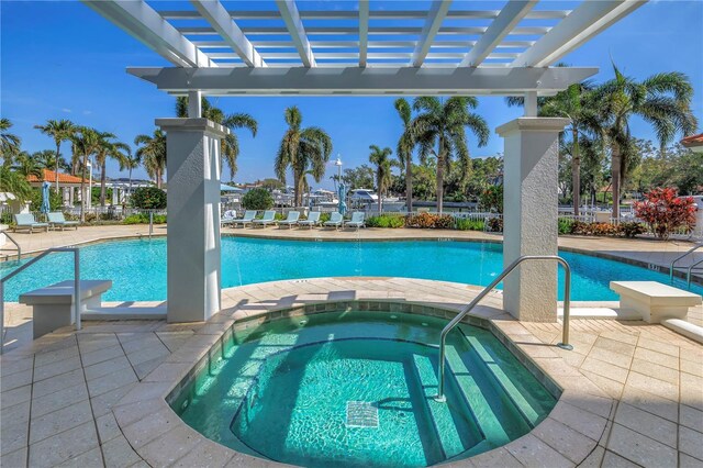 pool featuring a community hot tub, a patio, and a pergola