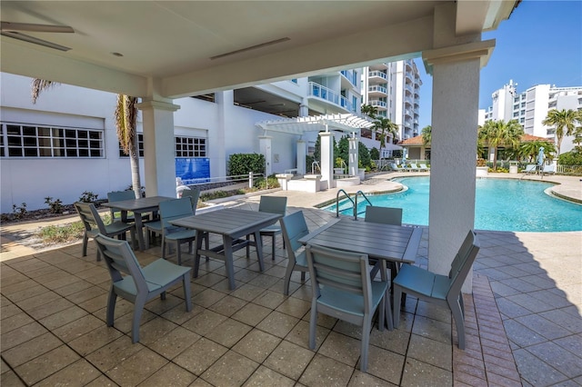 view of patio featuring outdoor dining space and a community pool