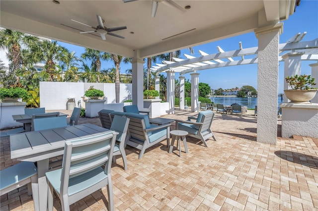 view of patio / terrace featuring outdoor dining area, a water view, a ceiling fan, fence, and a pergola