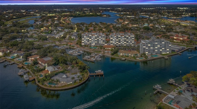 aerial view at dusk featuring a water view