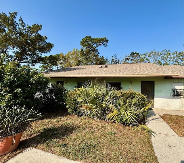 view of front of home featuring roof with shingles and stucco siding