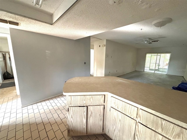 unfurnished room with a ceiling fan, visible vents, and a textured ceiling