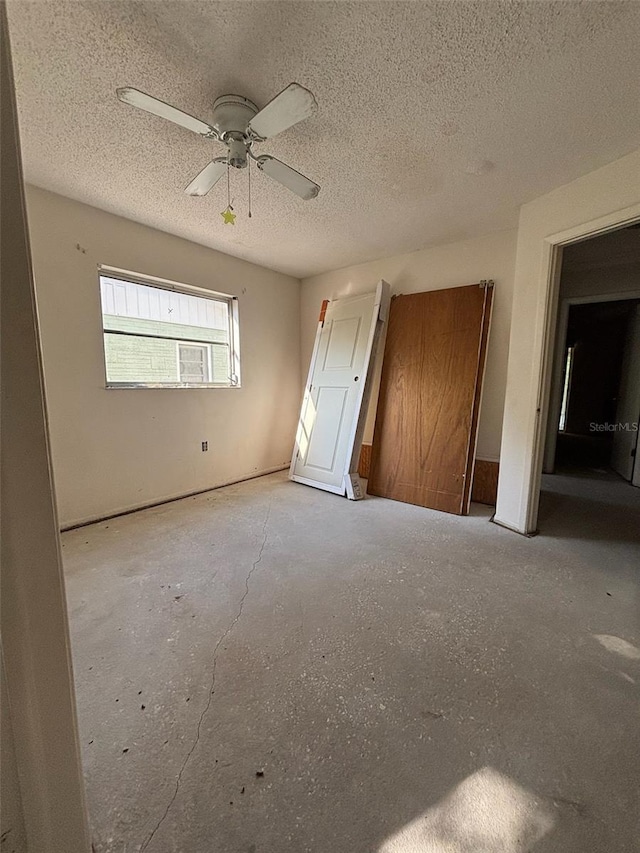 unfurnished bedroom featuring a textured ceiling and ceiling fan