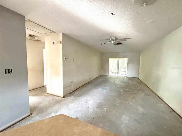 spare room with unfinished concrete flooring, a textured ceiling, and a ceiling fan