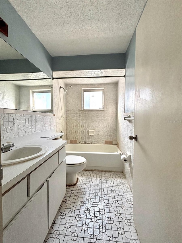 bathroom with vanity, toilet, washtub / shower combination, and a textured ceiling