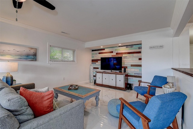 living room with an accent wall, a ceiling fan, visible vents, marble finish floor, and ornamental molding